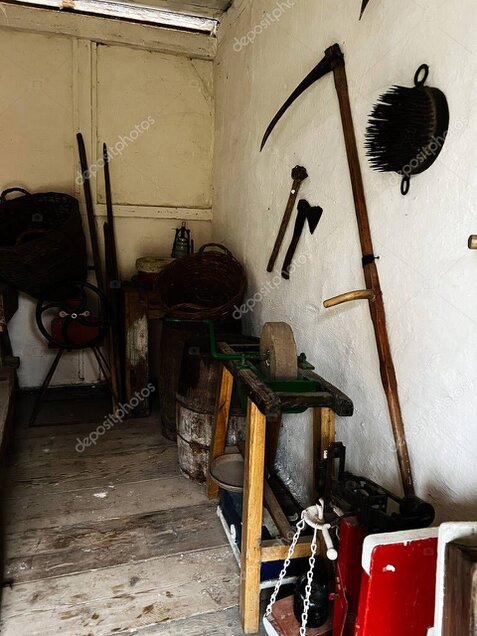 Teilnehmer beim Dengeln einer Sense im Workshop